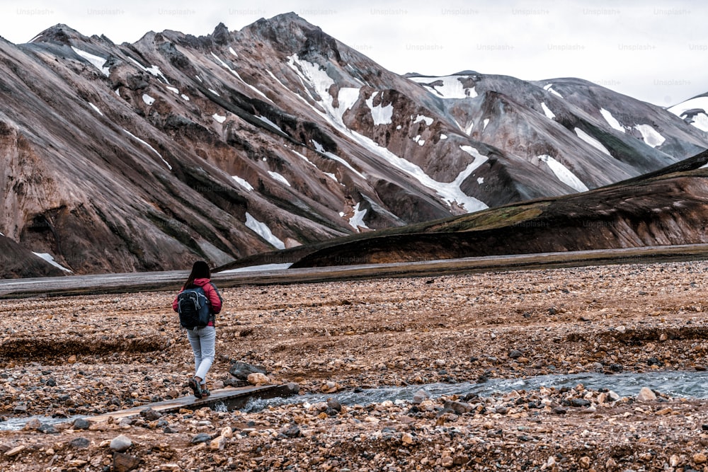 Escursionismo del viaggiatore a Landmannalaugar paesaggio naturale surreale nell'altopiano dell'Islanda, nordico, Europa. Bellissimo terreno di montagna innevato, colorato famoso per il trekking estivo, l'avventura e le passeggiate all'aria aperta.