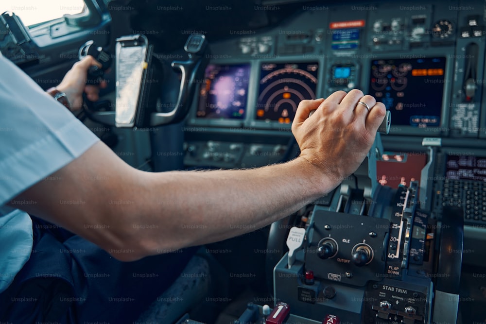 Foto recortada de um capitão de companhia aérea experiente empurrando o acelerador para aumentar o empuxo do motor