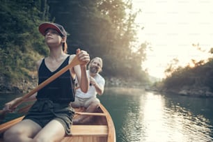Couple paddling canoe on a forest lake, copy space.
