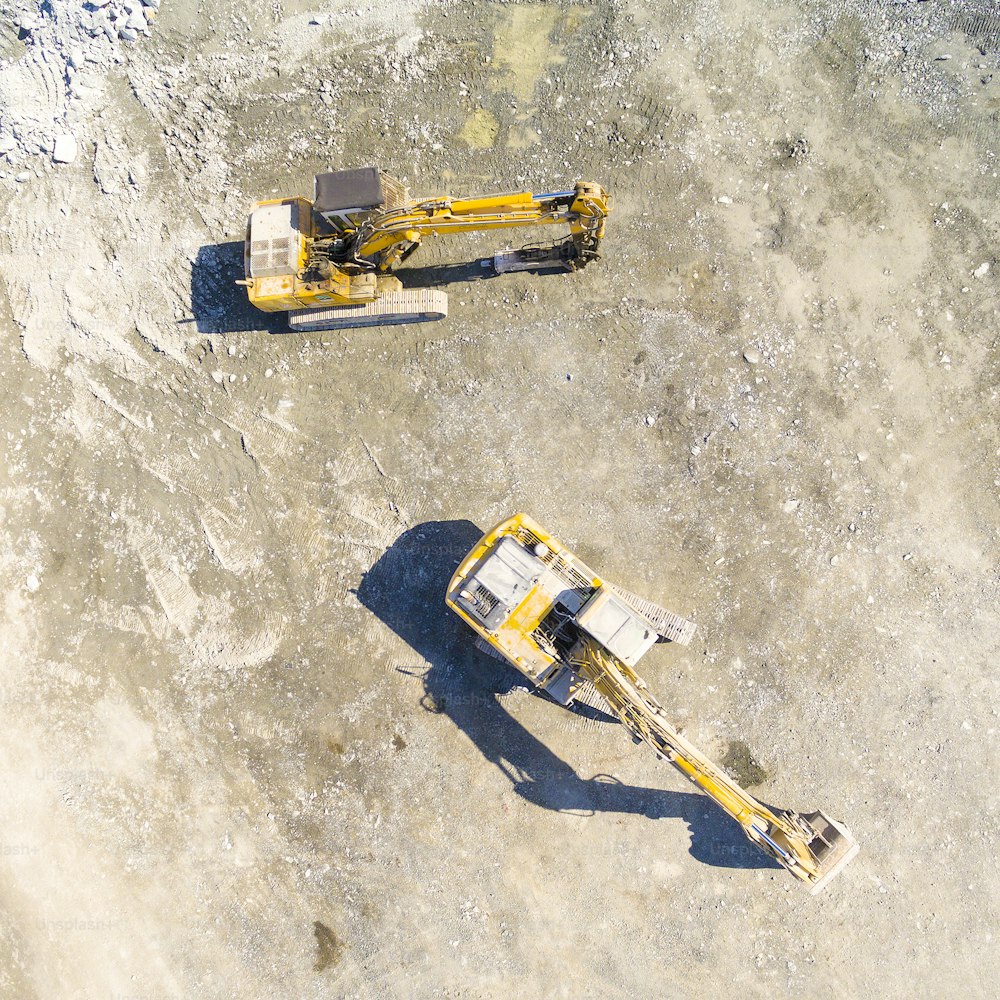 露天掘り鉱山や建設現場の掘削機の航空写真。上から見た重工業。ドローンからの産業背景。
