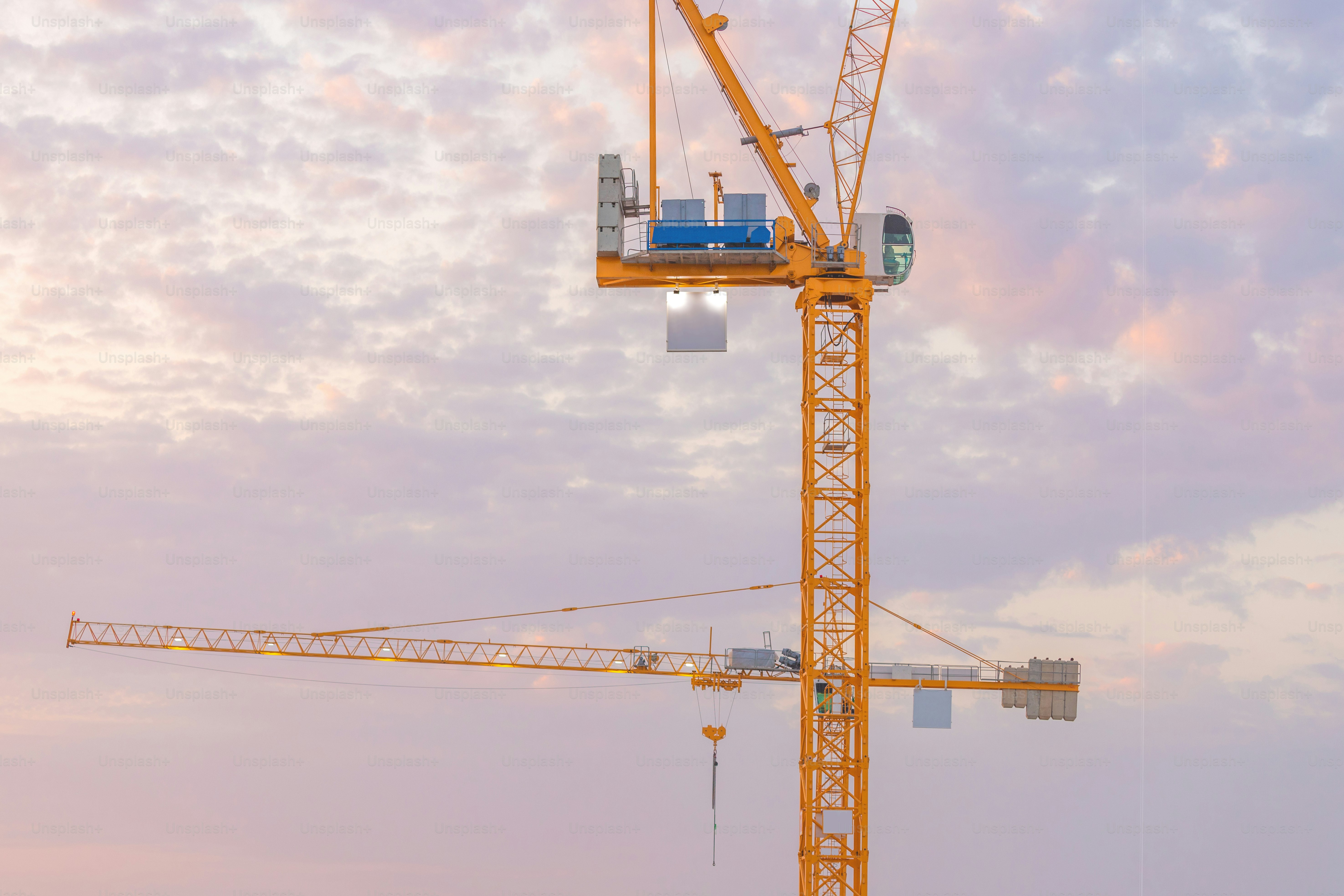 guindastes industriais altos no canteiro de obras durante a construção do arranha-céu. Conceito de imóveis residenciais e investimento em economia