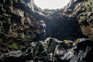 Woman traveler explore lava tunnel in Iceland. Raufarholshellir is a beautiful hidden world of cave. It is one of the longest and best-known lava tubes in Iceland, Europe for incredible adventure.