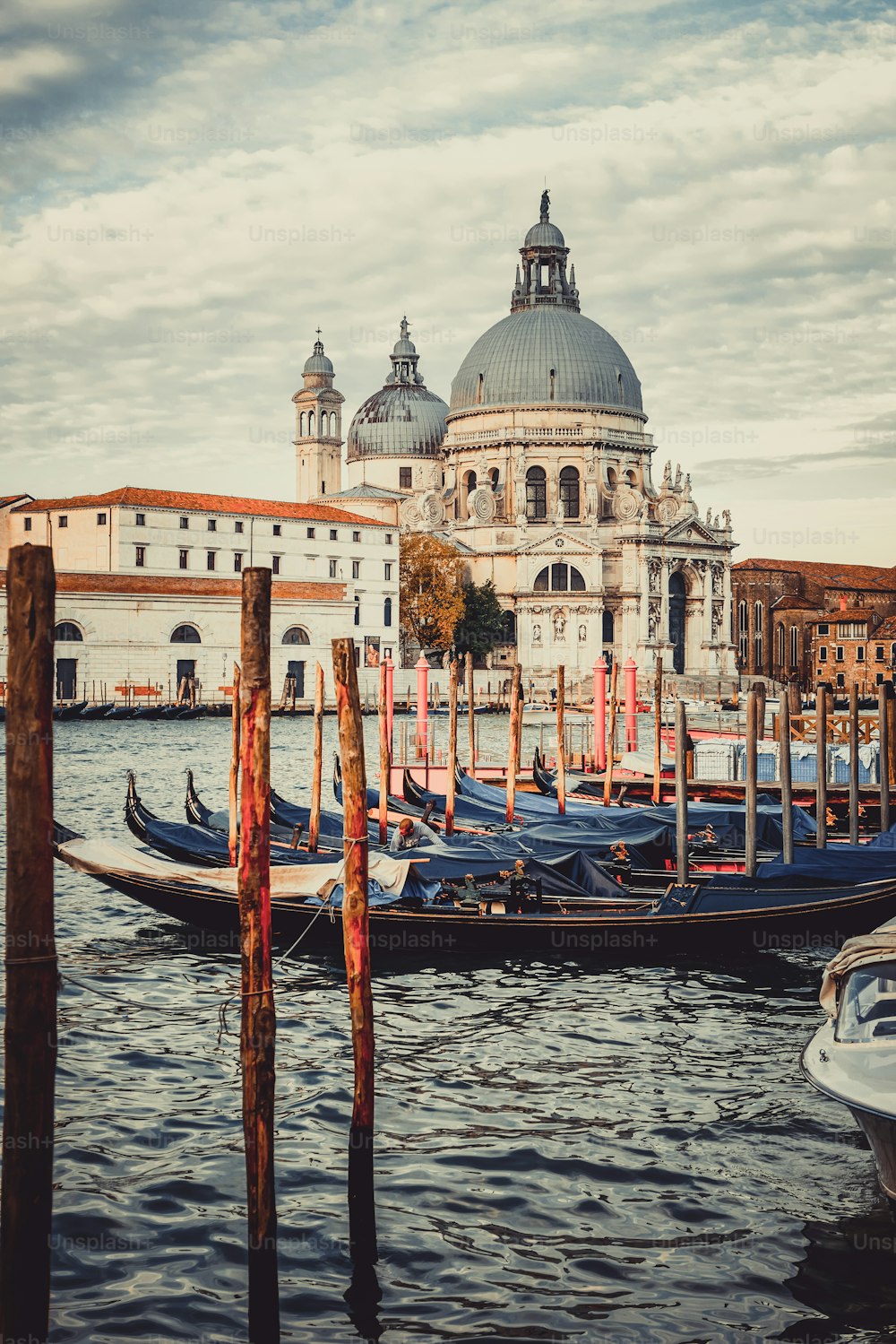 Gondola boats in Venice Italy with gorgeous view of Basilica Santa Maria della Salute. Venice is famous travel destination in Italy for its unique cityscape and culture.
