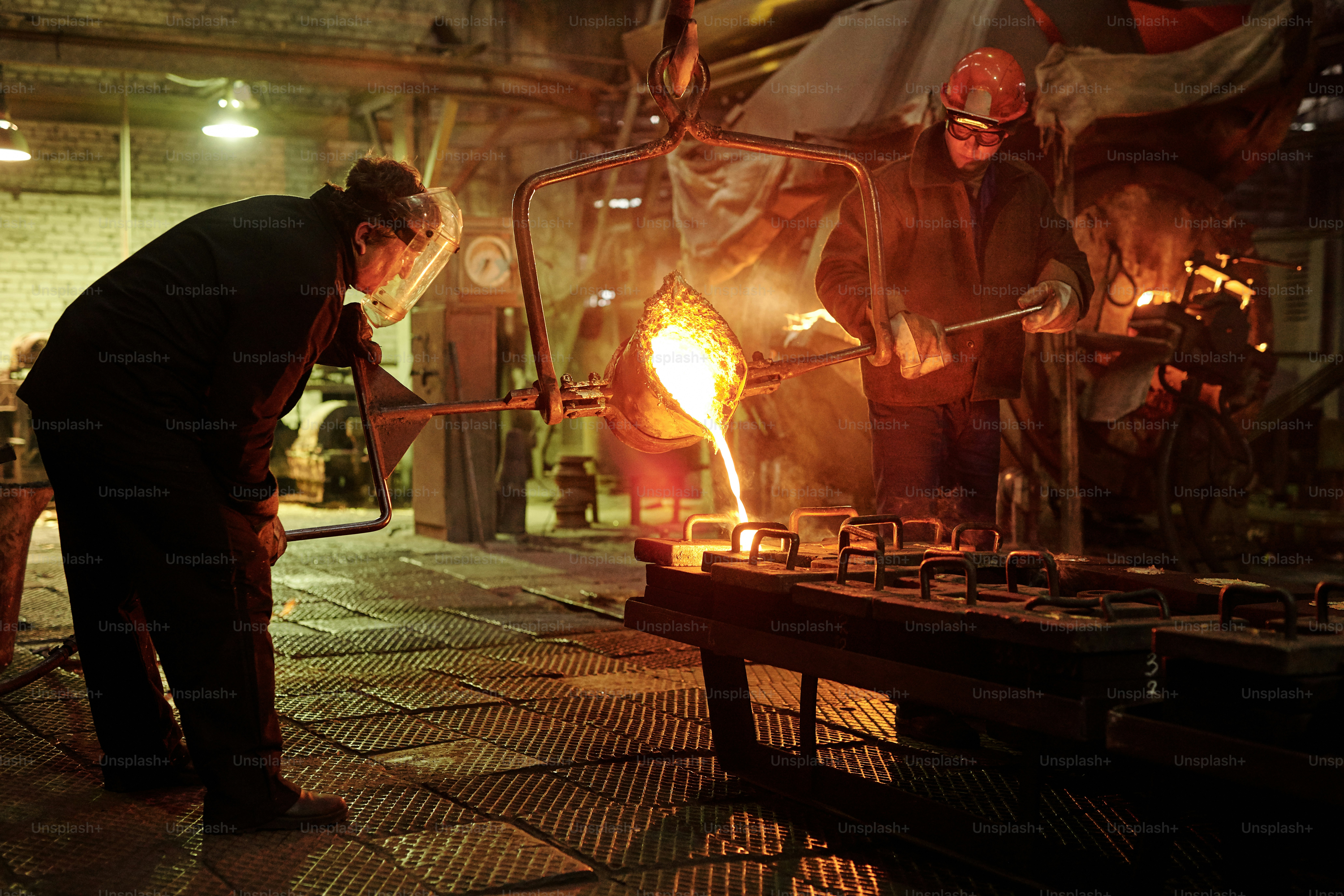 Steel workers melting iron in furnace steel mill