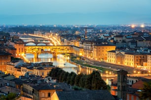 イタリアの夜のスカイラインにあるフィレンツェのヴェッキオ橋。フィレンツェはイタリア中部のトスカーナ地方の首都です。フィレンツェは、イタリアの中世の貿易の中心地であり、過去の時代の最も裕福な都市でした。