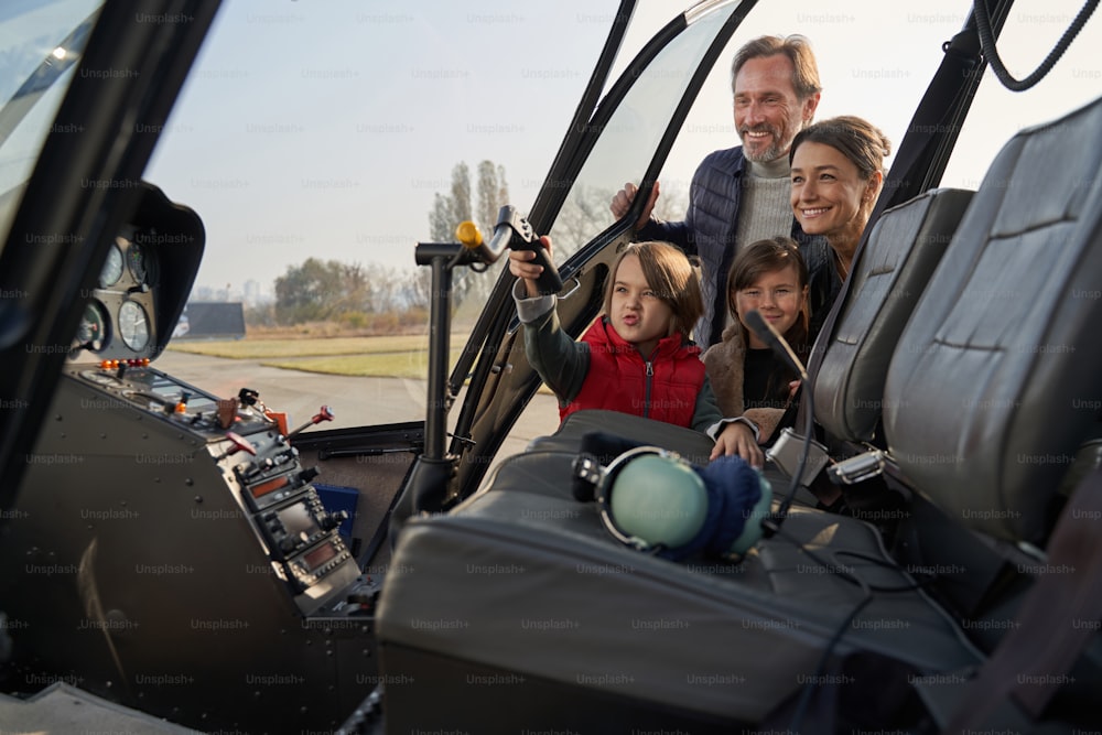 Des parents joyeux qui emmènent leurs adorables enfants dans une aventure palpitante en hélicoptère