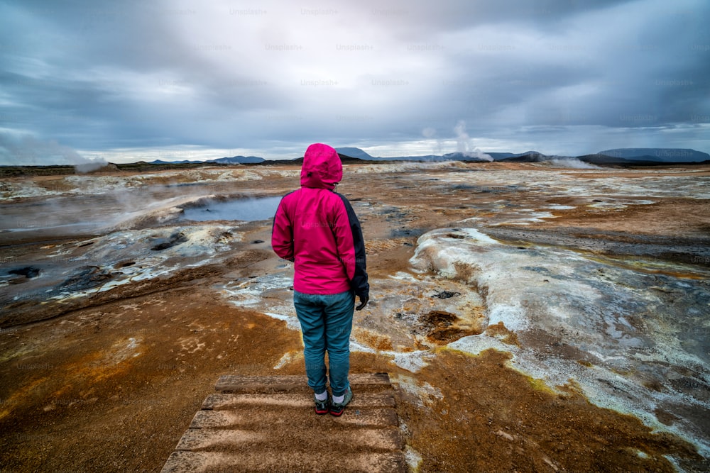여자 여행자가 아이슬란드의 흐베리르를 여행합니다. 흐베리르(아이슬란드어: Hverarond)는 미바튼의 지열 지대이다. 유럽 아이슬란드 북동부 크라플라 미바튼 호수 근처의 유명한 여행지입니다.