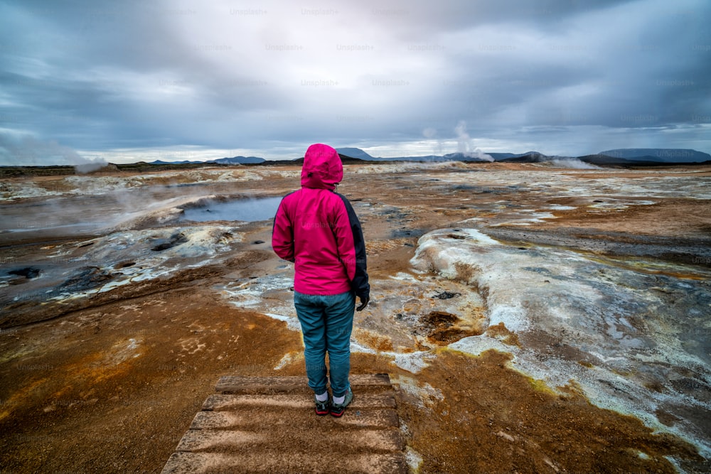 Weibliche Reisende reist nach Hverir in Island. Hverir (isländisch: Hverarond) ist ein geothermisches Gebiet in Myvatn. Es ist ein berühmtes Reiseziel in der Nähe des Myvatn-Sees, Krafla nordöstliche Region Islands, Europa.