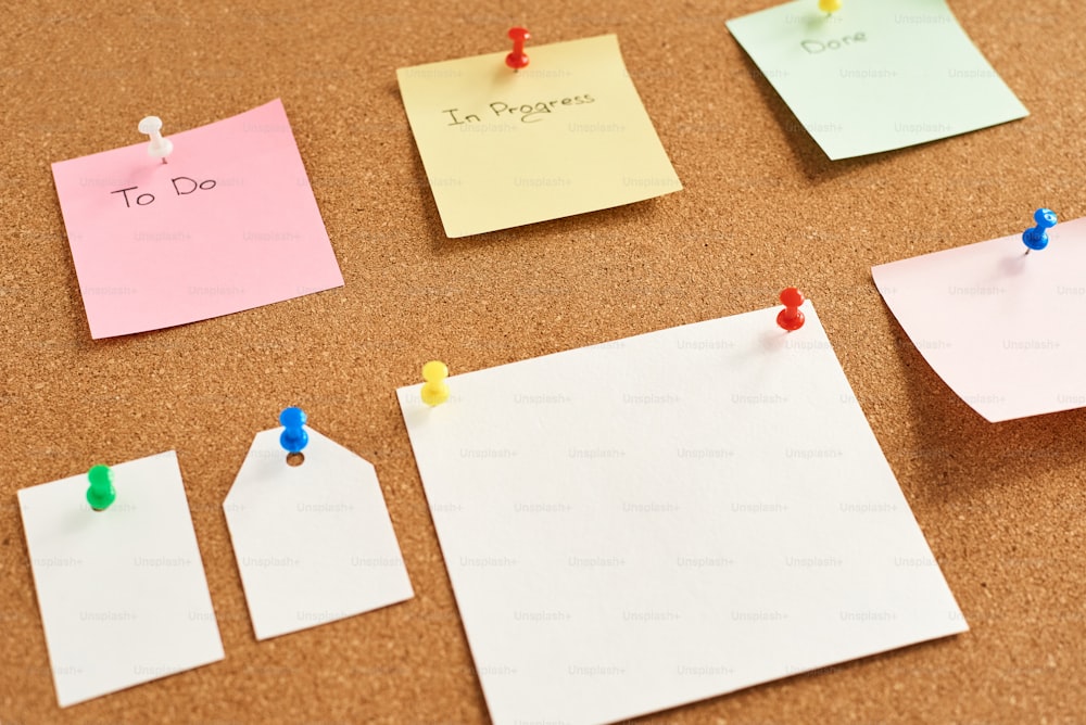 Notas de papel de colores con las palabras "To do", "In progress" y "Done" fijadas en un tablero de corcho