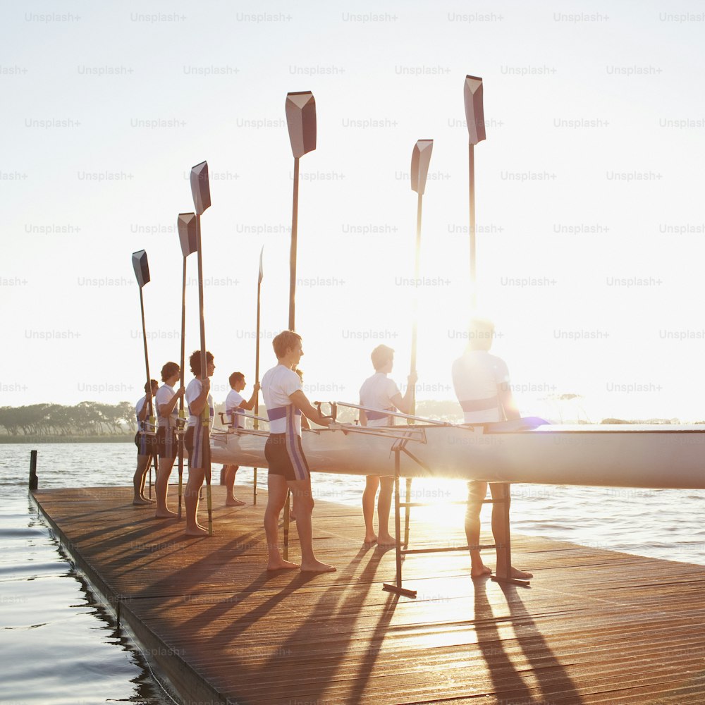 Eine Gruppe von Menschen, die auf einem Dock neben einem Boot stehen