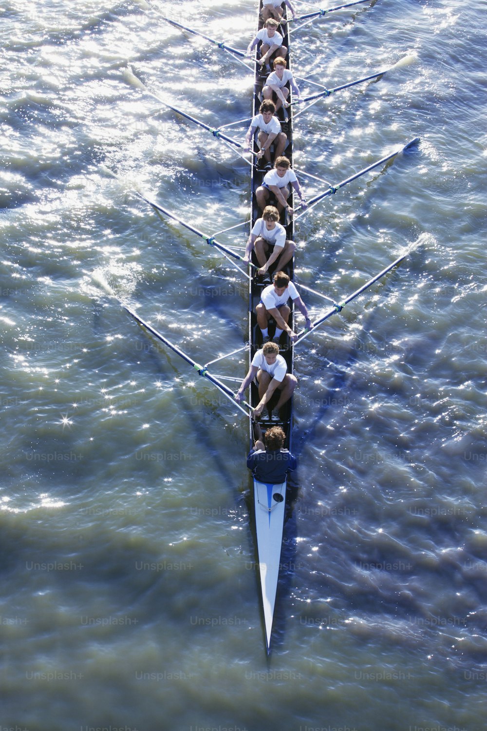 Eine Gruppe von Menschen, die ein langes Boot im Wasser rudern