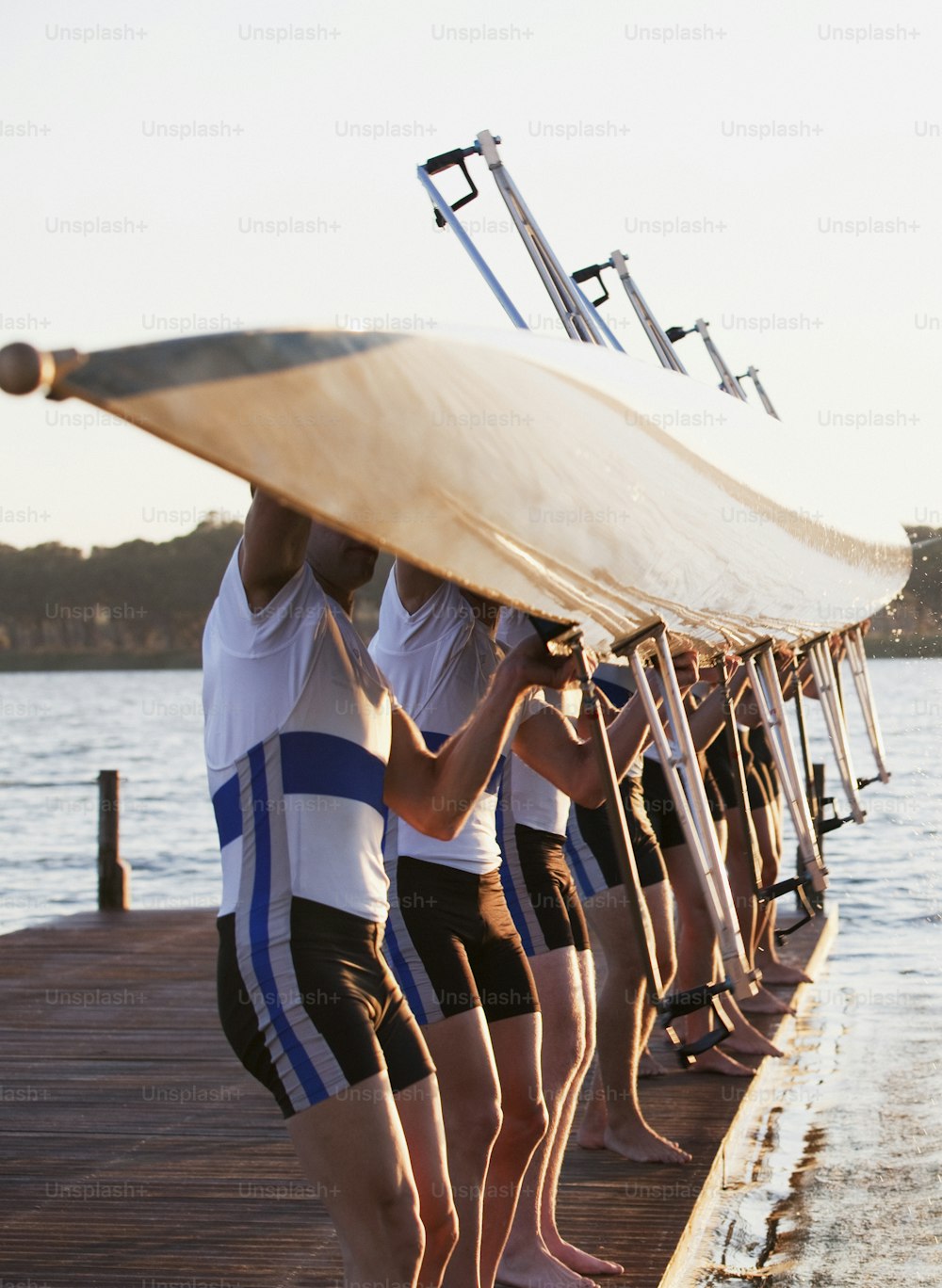 a group of people standing on a dock with a surfboard