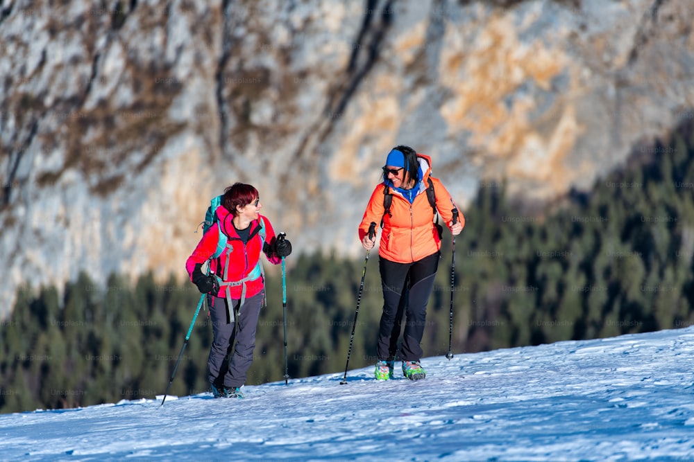 Zwei freundliche Frauen während einer Bergwanderung im Schnee