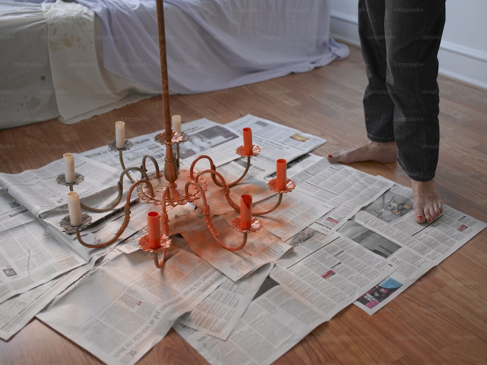 a person standing over a bunch of newspapers on the floor