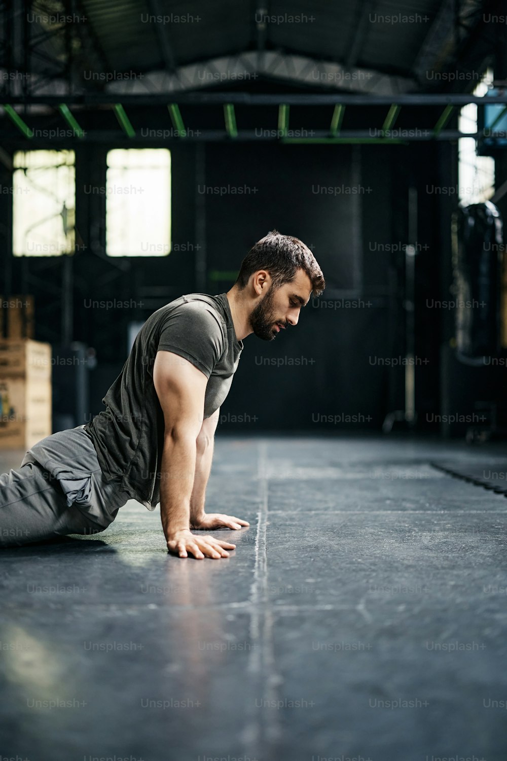 Athletic man warming up for sports training while working out in a gym. Copy space.