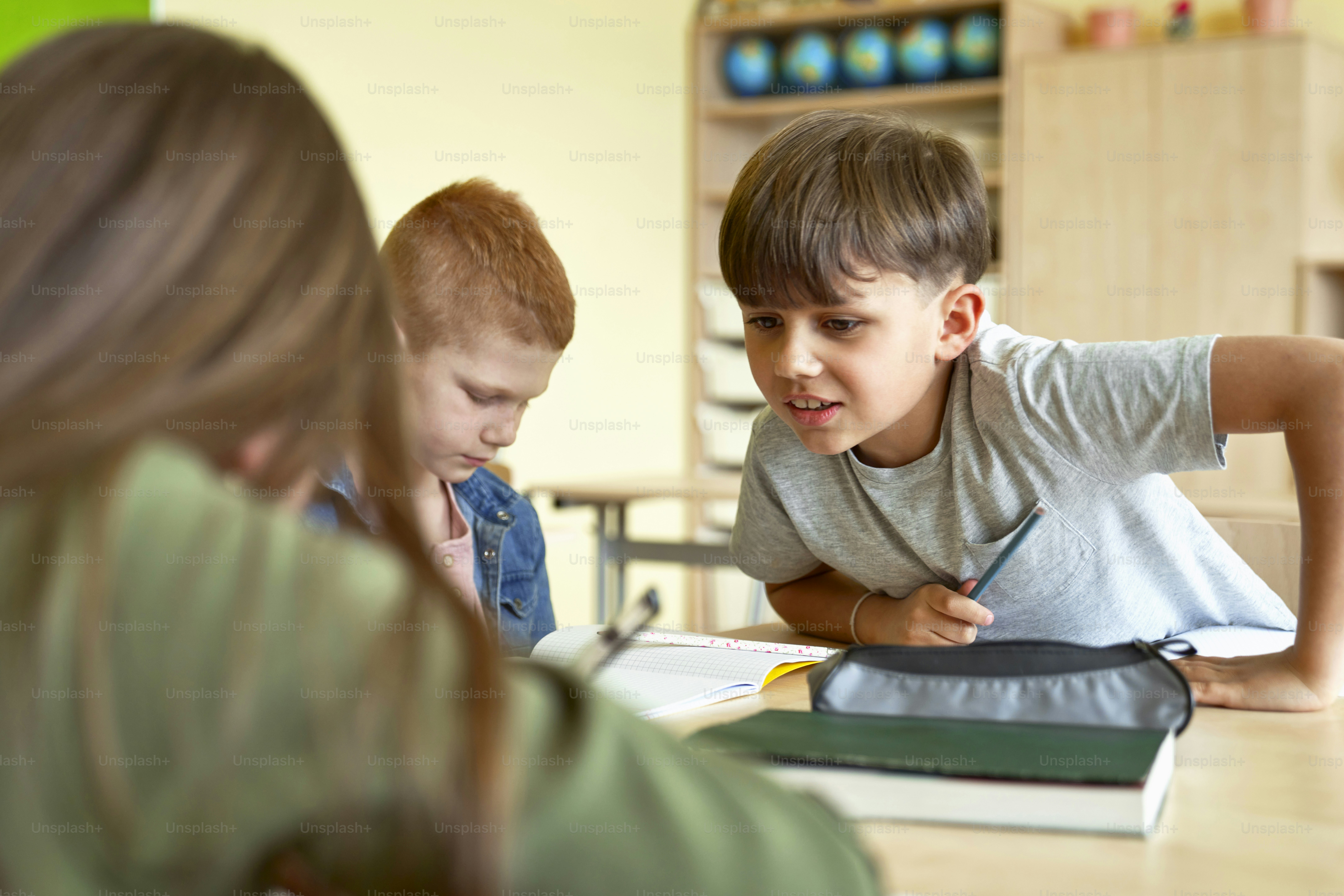 Schoolboy learning together during school lesson photo – Books Image on ...
