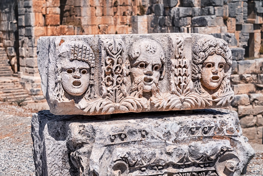Bas relevo com rostos romanos e gregos esculpidos em uma coluna de pedra na antiga cidade de Myra, na Turquia, perto da aldeia de Demre