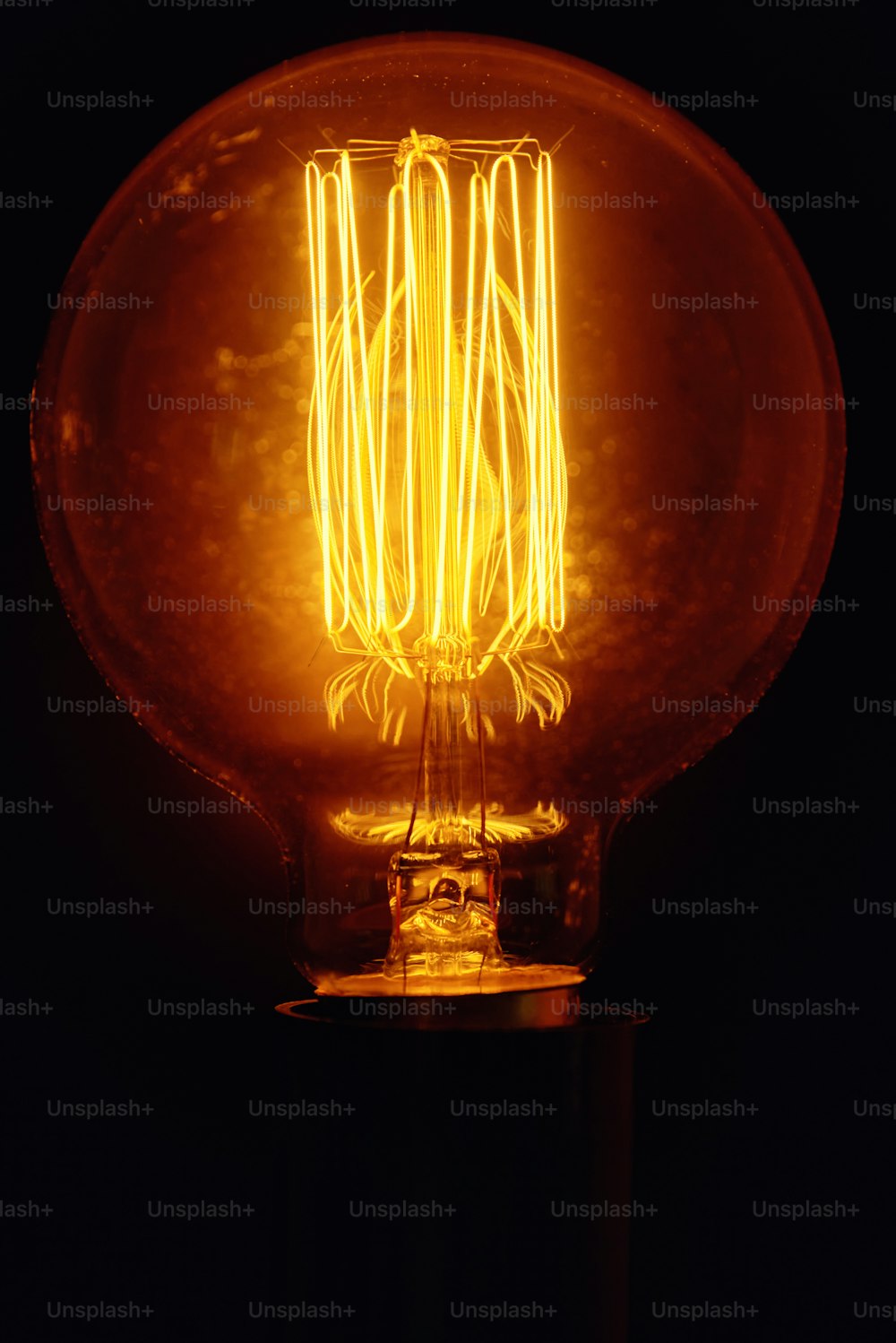 Vintage light bulb on black background, close up Glowing edison bulb