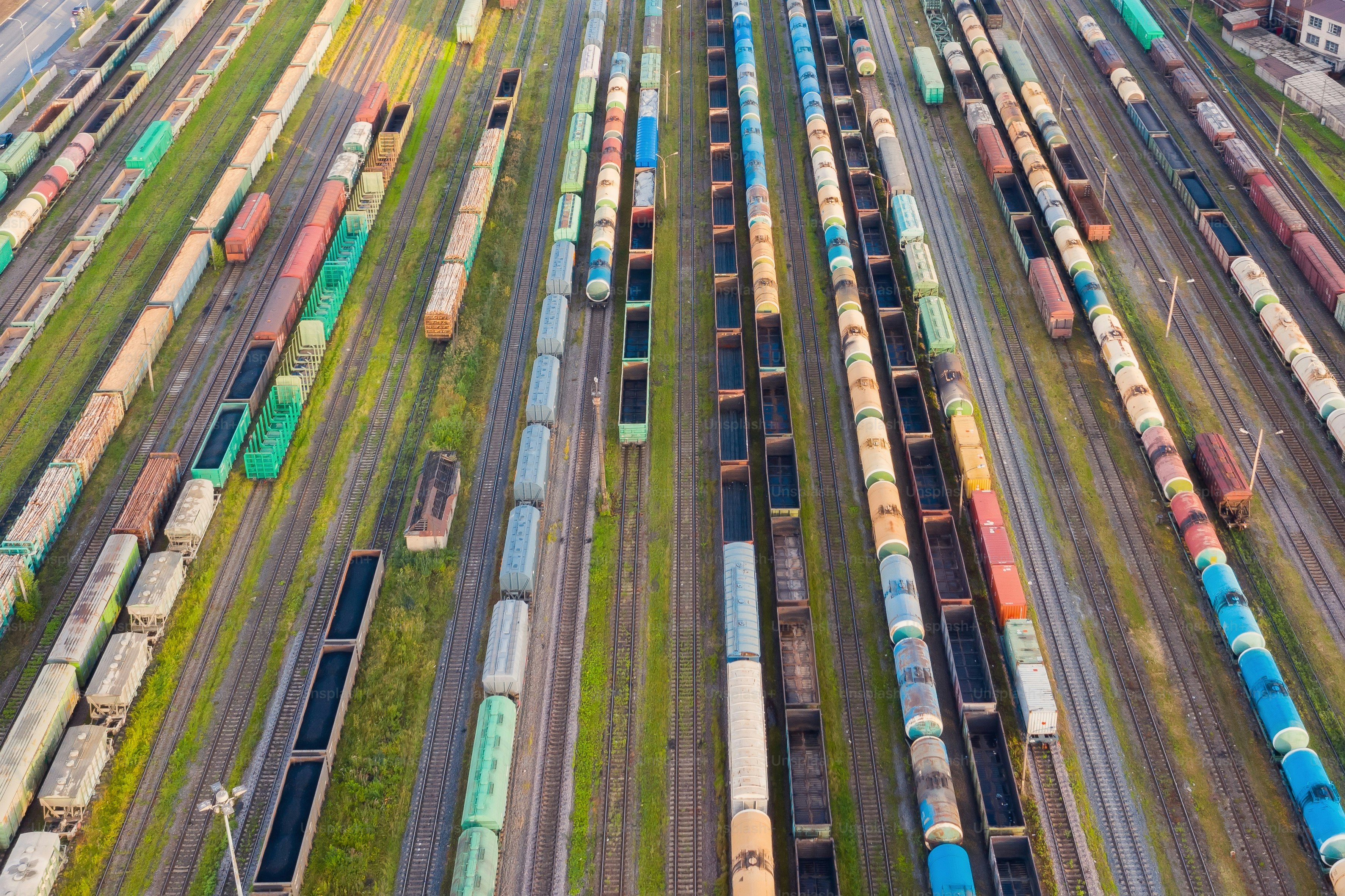 Aerial perspective view of railroad tracks, cargo sorting station. Many different railway cars with cargo and raw materials