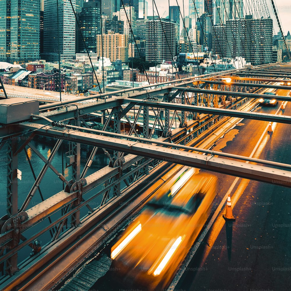 ニューヨークのブルックリン橋を渡るタクシー、マンハッタンのスカイラインを背景に