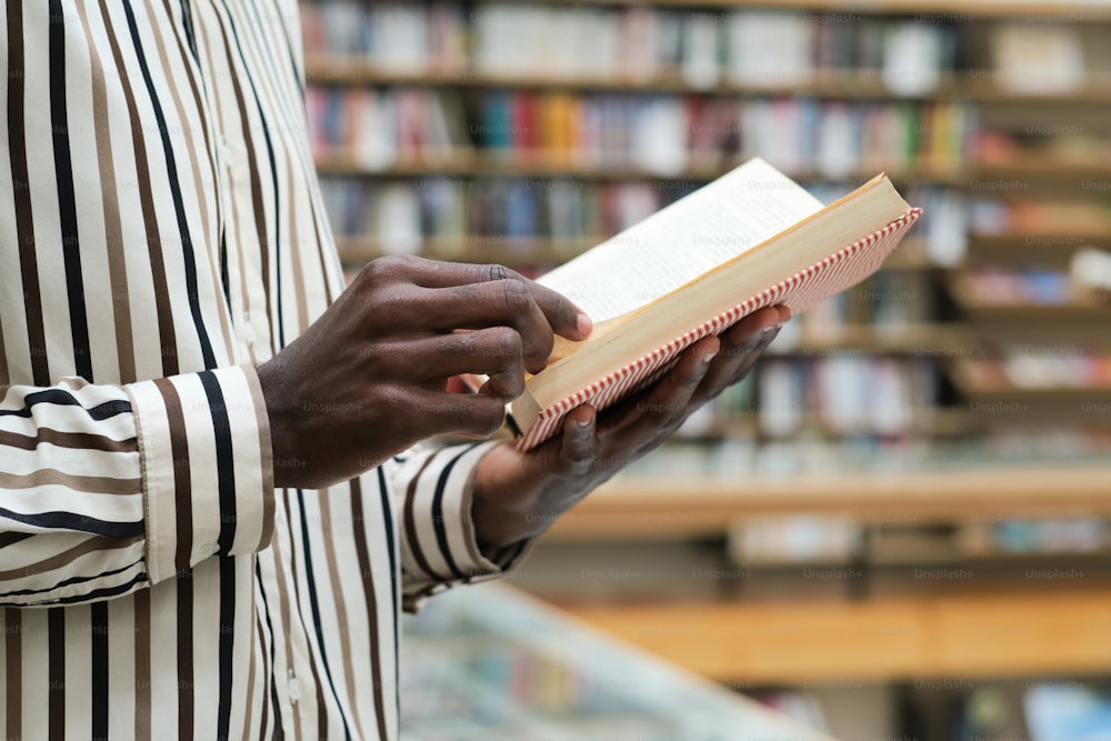 Nahaufnahme eines afrikanischen Mannes, der ein Buch in den Händen hält und liest