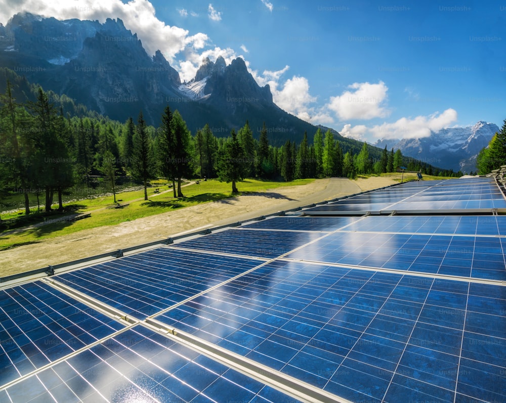 Pannello a celle solari nel paesaggio di campagna contro il cielo soleggiato e gli sfondi di montagna. L'energia solare è l'innovazione per la sostenibilità dell'energia mondiale. Risorse sostenibili.