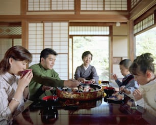 Família de três gerações comendo sushi