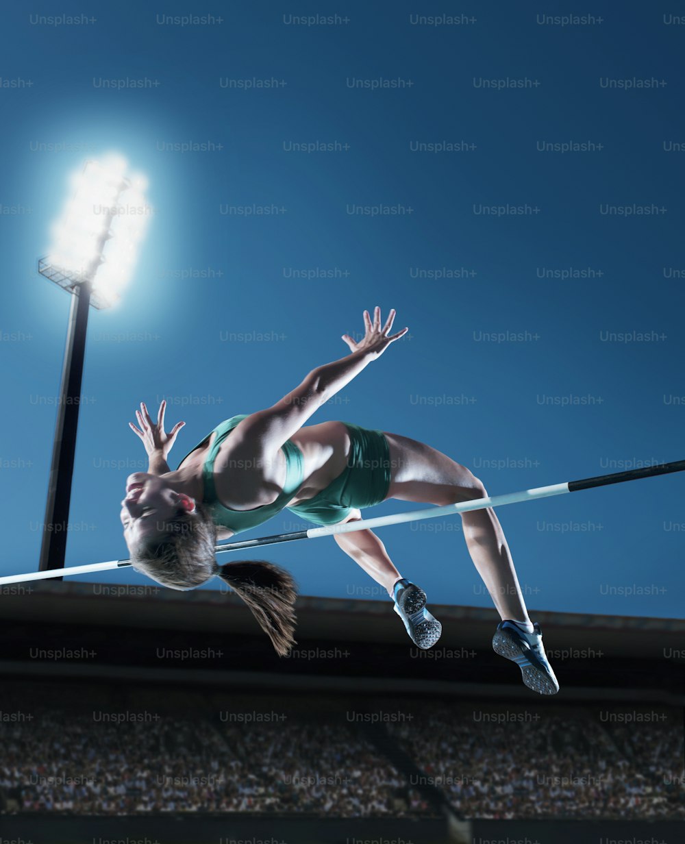 a woman jumping high in the air on a high jump