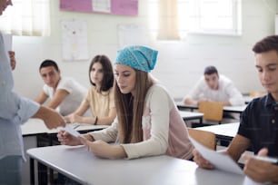 Bad news.  Professor giving exam to his student. Focus is on background.