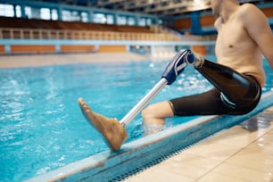 Close-up of prosthetic leg of adaptive swimmer at indoor swimming pool.