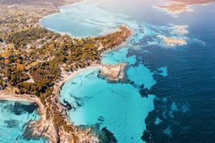 Vue aérienne du bord de mer paradisiaque avec différentes nuances d’eau turquoise. Récifs coralliens en profondeur et plages de sable isolées dans le village de villégiature de Vourvourou en Grèce