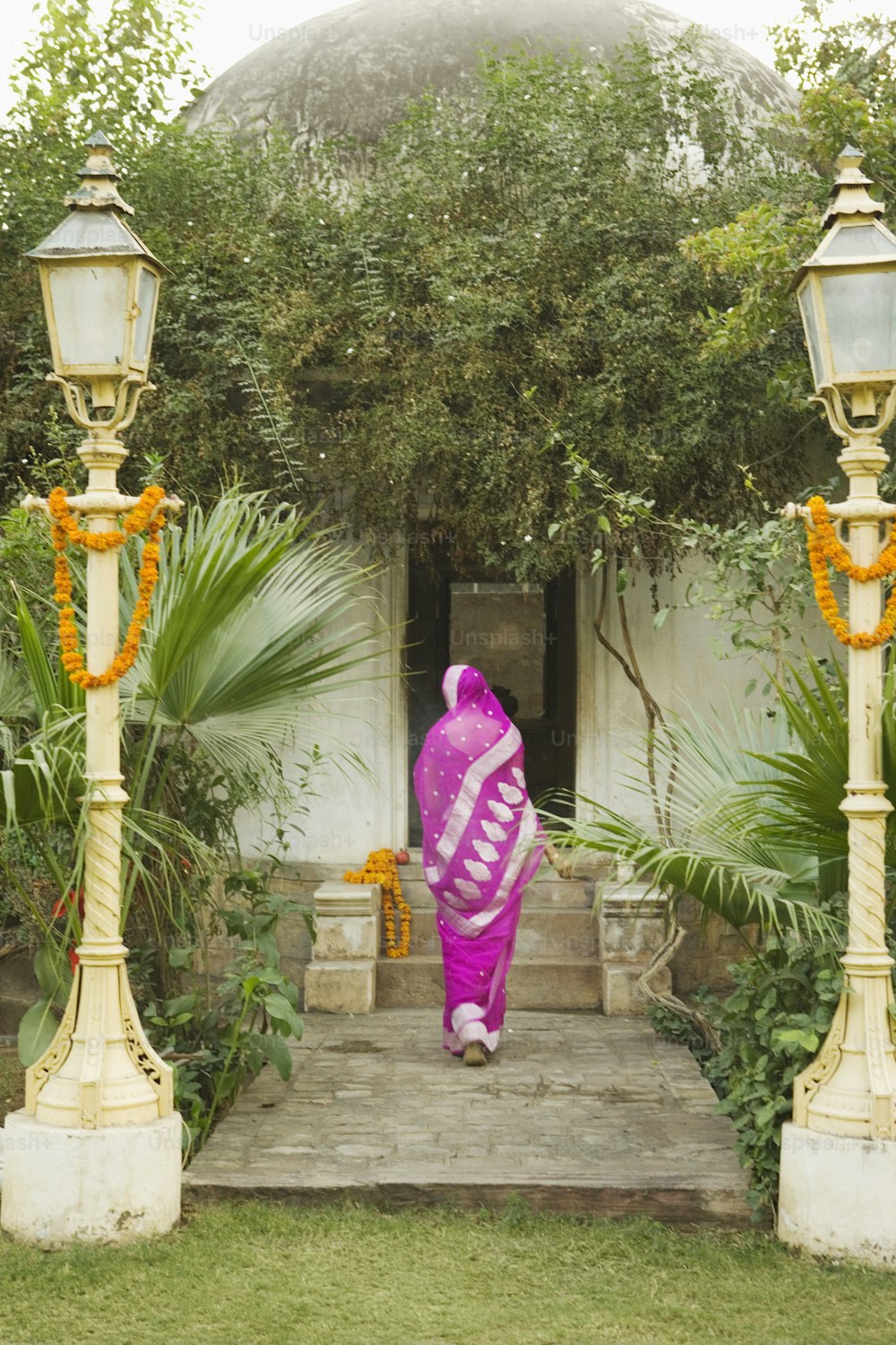 Una donna in un sari rosa che cammina su una serie di gradini