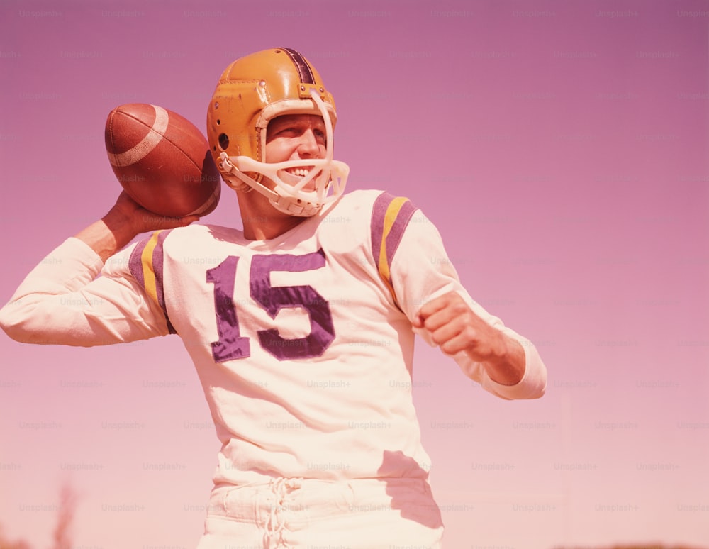 UNITED STATES - CIRCA 1960s:  American football player, holding football, ready to throw.