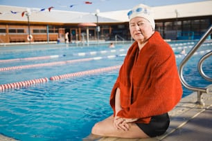a woman sitting on the edge of a swimming pool