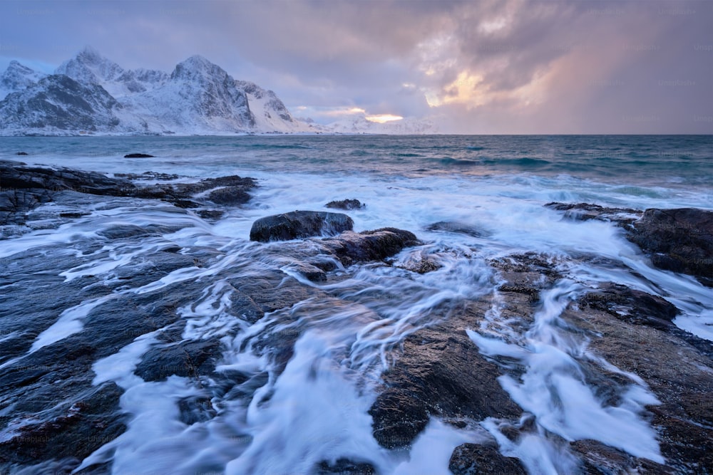 겨울에 해질녘에 피요르드의 바위 해안에 있는 노르웨이 바다의 해변. 바레이드 해변, 로포텐 섬, 노르웨이