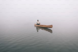 Vista trasera del hombre remando en canoa en invierno, espacio de copia.