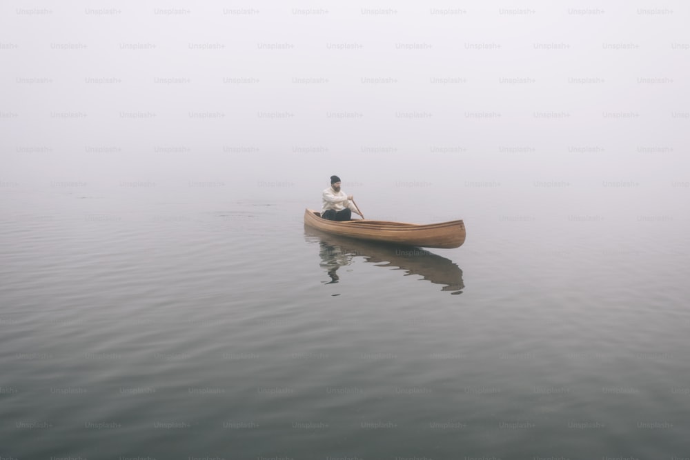 Vista traseira do homem remando canoa no inverno, espaço de cópia.
