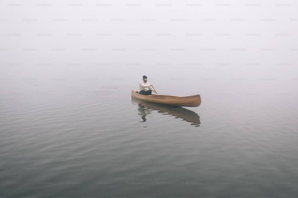 Rear view of man paddling canoe in the winter, copy space.