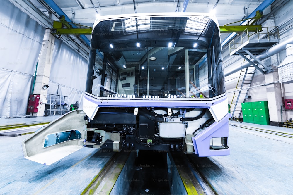 Ein Arbeitstag moderner automatischer Busfertigung mit unfertigen Autos Arbeiter in schützender Uniform-Automobilproduktion
