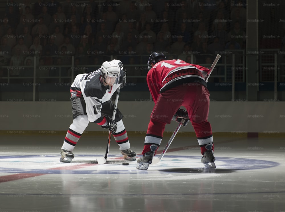 a couple of men playing a game of ice hockey