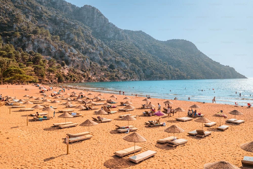 2020 年 9 月 9 日、トルコ、ダルヤン: 豪華な太陽のパラソルとラウンジャー、細かい黄色の砂浜がある人気のリゾート イズトゥズ ビーチの空撮。海の楽園とリラクゼーションのコンセプト