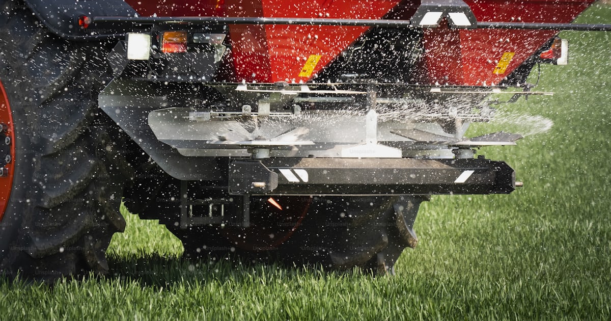 Foto zum Thema Traktor beim Ausbringen von Kunstdünger. Verkehr Foto zum Thema Traktor beim Ausbringen von Kunstdünger. Verkehr