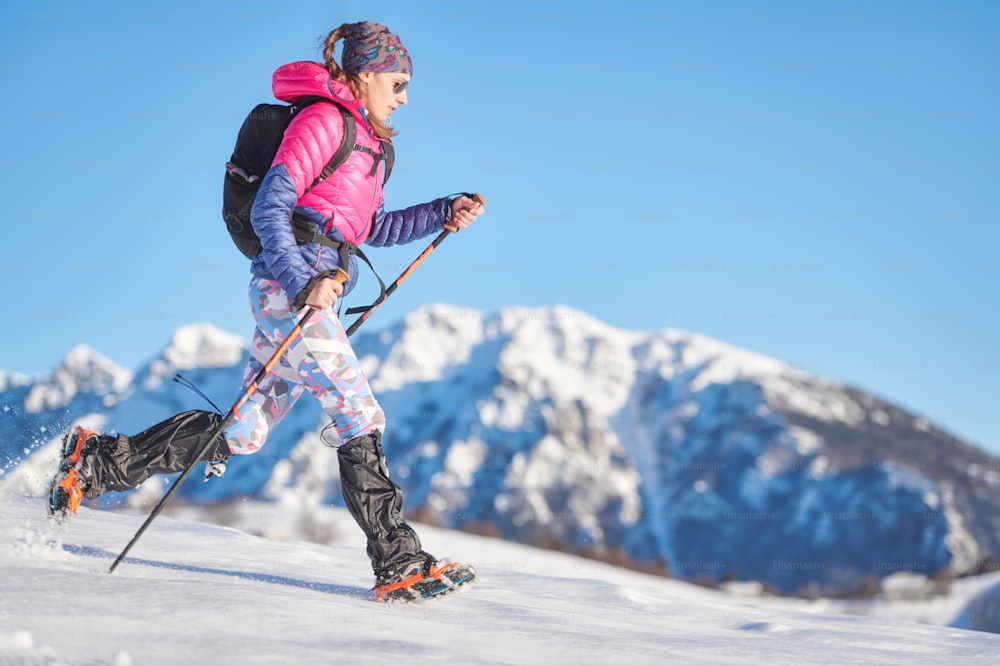 Young sporty woman in the snow with crampons and gaiters