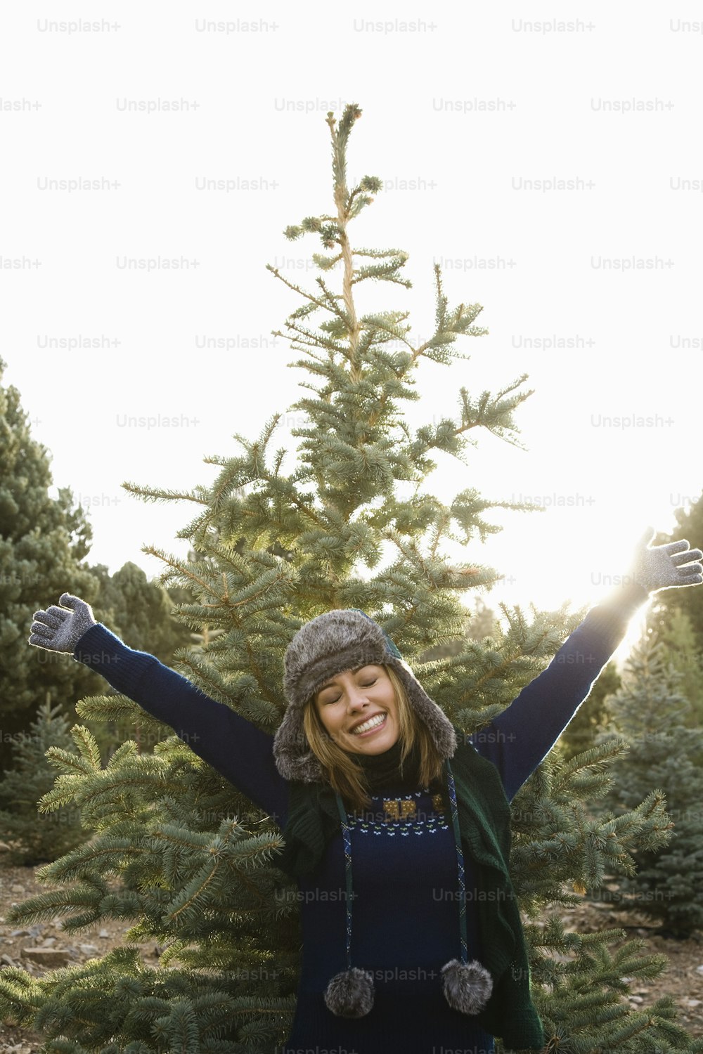 Una mujer parada frente a un árbol de Navidad