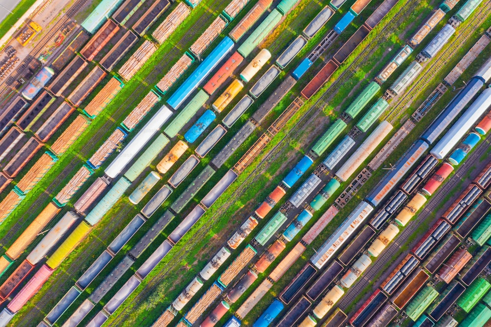 Cargo railway carriage. Aerial diagonally view from flying drone of colorful freight trains on the railway sort facility. Wagons with goods on railroad. Heavy industry, industrial concept scene