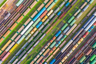 Güterbahnwagen. Luftschrägansicht von fliegenden Drohnen von bunten Güterzügen auf der Bahnsortieranlage. Waggons mit Waren auf der Eisenbahn. Schwerindustrie, industrielle Konzeptszene