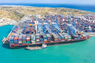 Huge ship with a large number of containers, moored to the port, cranes unload cargo. Great port, maritime transport, maritime traffic delivery concept