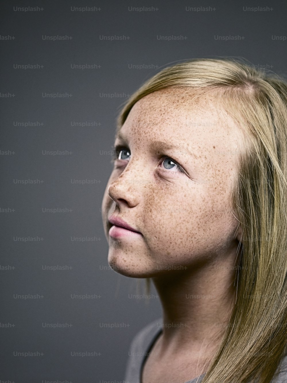 a young girl with freckled hair looking up