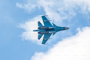 Un caza de combate vuela realizando una maniobra en el aire con el rastro de un par de nubes
