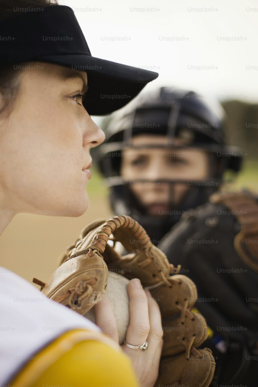 a woman holding a catchers mitt next to a man